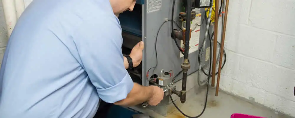 Furnace repair technician inspecting and servicing a home heating system in Wilmington, NC