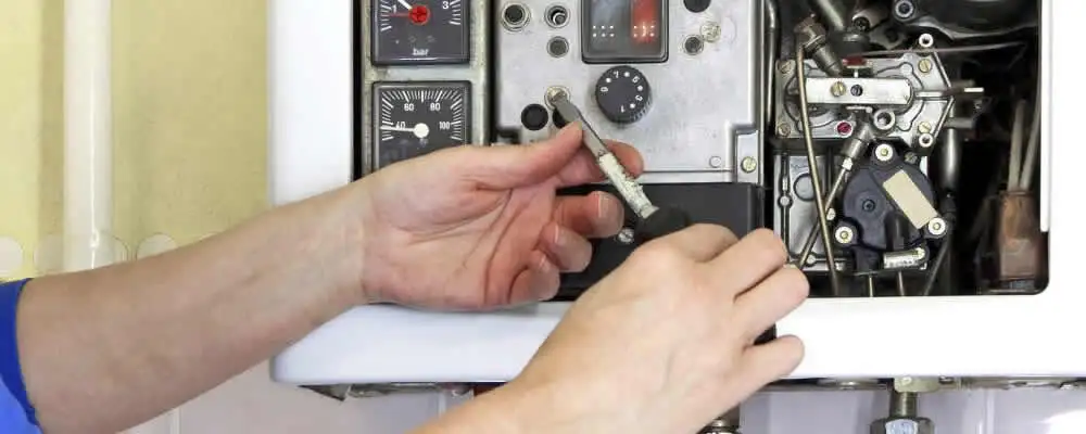 Heating repair technician adjusting boiler controls and components in Wilmington, NC