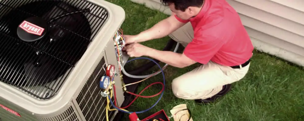 HVAC technician servicing an outdoor air conditioner unit in Wilmington, NC