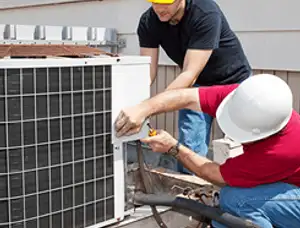 HVAC technicians repairing an outdoor AC unit on a rooftop in Wilmington, NC