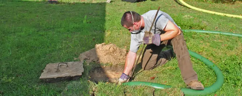 Septic pumping technician servicing a residential septic tank in Wilmington, NC